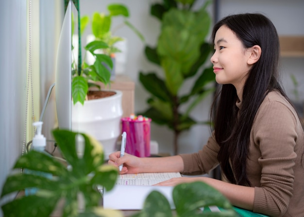 Aziatische student die thuis door computer en internet leert