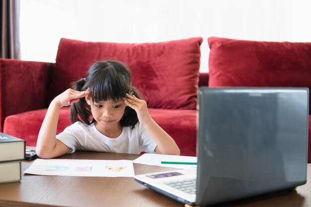 Aziatische studente online leerklas online studeren met laptop thuis.