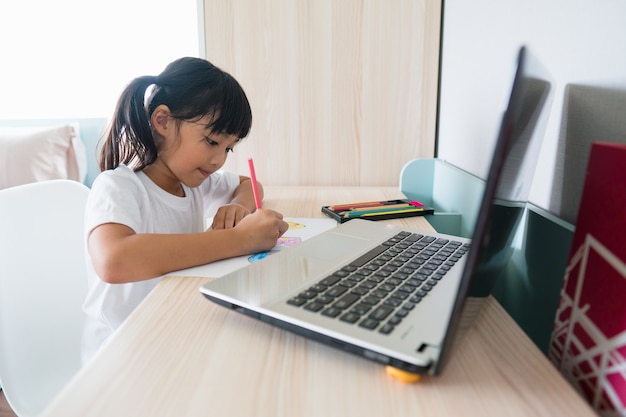 Aziatische studente online leerklas online studeren met laptop thuis.