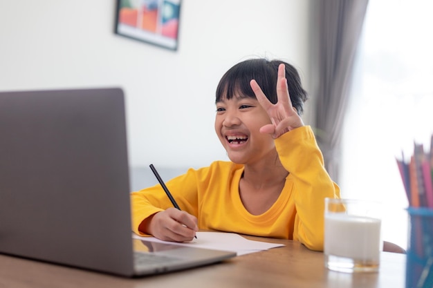 Aziatische studente online leerklas studeren online videogesprek zoomleraar, Gelukkig meisje leert Engels online met laptop thuis Nieuw normaal Covid-19 coronavirus Sociale afstand blijf thuis