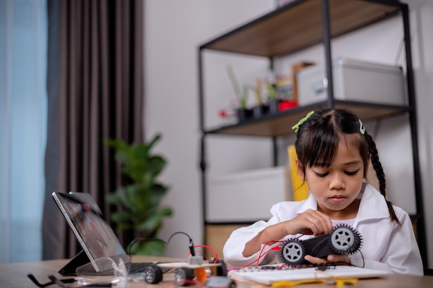 Aziatische studenten leren thuis door robotauto's en elektronische bordkabels te coderen in STEM STEAM wiskunde engineering wetenschap technologie computercode in robotica voor kinderconcepten