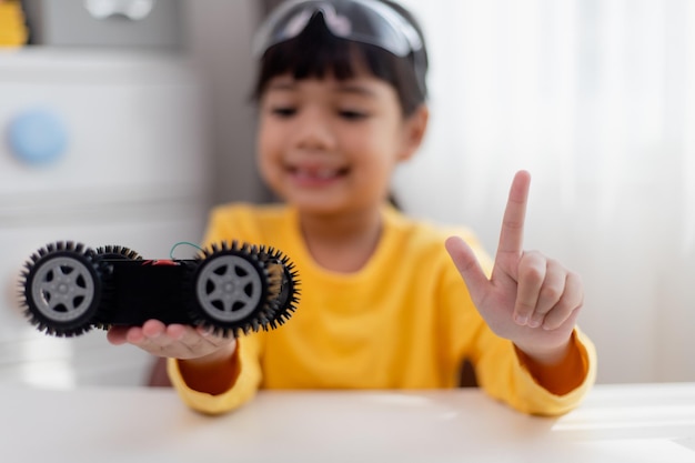 Aziatische studenten leren thuis in het coderen van robot auto's en elektronische boord kabels in STEM STEAM wiskunde techniek wetenschap technologie computer code in robotica voor kinderen concept