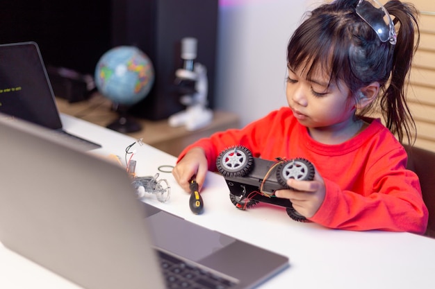 Aziatische studenten leren thuis in het coderen van robotauto's en elektronische bordkabels in STEM STEAM wiskunde engineering wetenschap technologie computercode in robotica voor kinderen concept