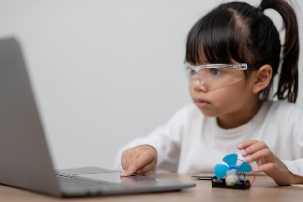 Aziatische studenten leren thuis in het coderen van robotauto's en elektronische bordkabels in STEM STEAM wiskunde engineering wetenschap technologie computercode in robotica voor kinderen concept