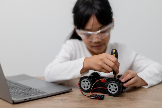 Aziatische studenten leren thuis in het coderen van robotauto's en elektronische bordkabels in STEM STEAM wiskunde engineering wetenschap technologie computercode in robotica voor kinderen concept