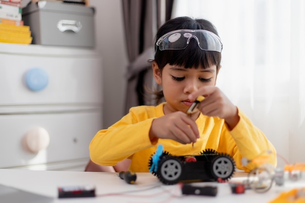 Aziatische studenten leren thuis in het coderen van robotauto's en elektronische bordkabels in STEM STEAM wiskunde engineering wetenschap technologie computercode in robotica voor kinderen concept
