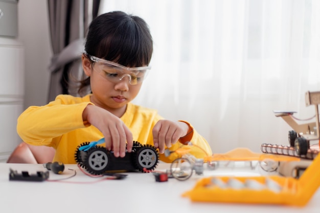 Aziatische studenten leren thuis in het coderen van robotauto's en elektronische bordkabels in STEM STEAM wiskunde engineering wetenschap technologie computercode in robotica voor kinderen concept