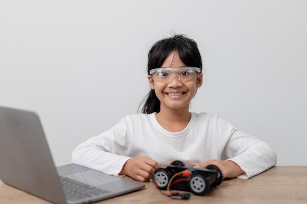 Aziatische studenten leren thuis in het coderen van robotauto's en elektronische bordkabels in STEM STEAM wiskunde engineering wetenschap technologie computercode in robotica voor kinderen concept