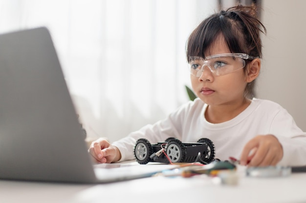 Aziatische studenten leren thuis in het coderen van robotauto's en elektronische bordkabels in STEM STEAM wiskunde engineering wetenschap technologie computercode in robotica voor kinderen concept