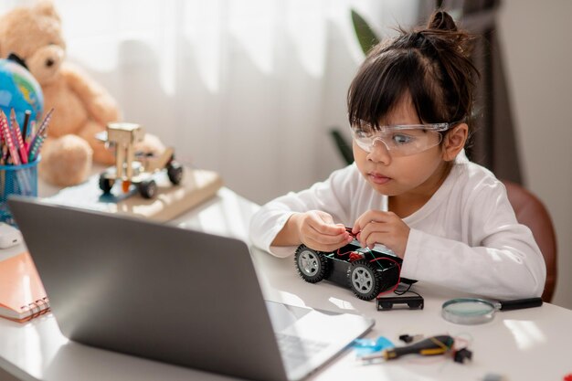 Aziatische studenten leren thuis in het coderen van robotauto's en elektronische bordkabels in STEM STEAM wiskunde engineering wetenschap technologie computercode in robotica voor kinderen concept