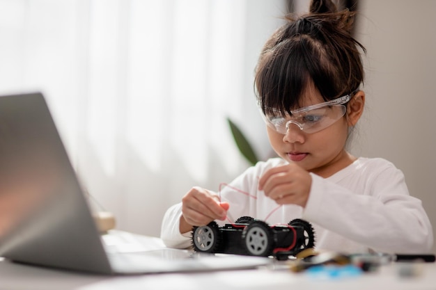 Aziatische studenten leren thuis in het coderen van robotauto's en elektronische bordkabels in STEM STEAM wiskunde engineering wetenschap technologie computercode in robotica voor kinderen concept