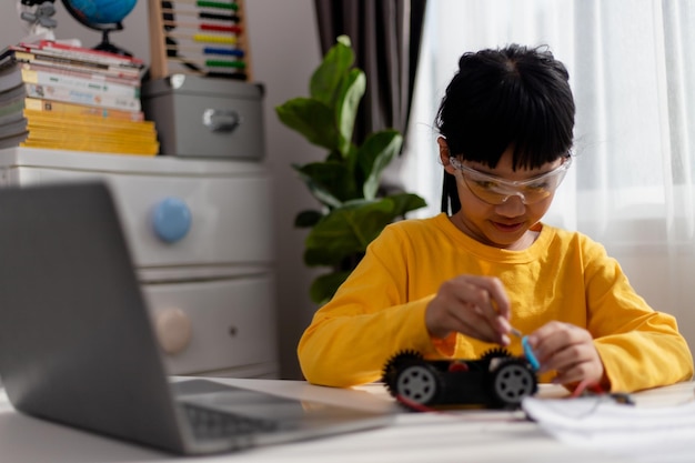 Aziatische studenten leren thuis in het coderen van robotauto's en elektronische bordkabels in STEM STEAM wiskunde engineering wetenschap technologie computercode in robotica voor kinderen concept