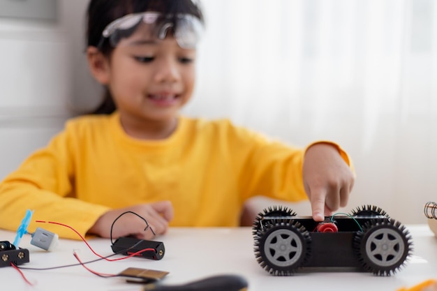 Aziatische studenten leren thuis in het coderen van robotauto's en elektronische bordkabels in STEM STEAM wiskunde engineering wetenschap technologie computercode in robotica voor kinderen concept