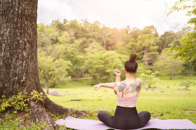 Aziatische tatoeage jonge vrouw doet yoga in het park