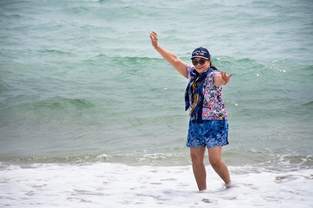 Aziatische Thaise oude vrouwen reizen poseren voor het nemen van foto's en spelen in de zee op het Ban Krut-strand op 30 januari 2018 in Prachuap Khiri Khan, Thailand