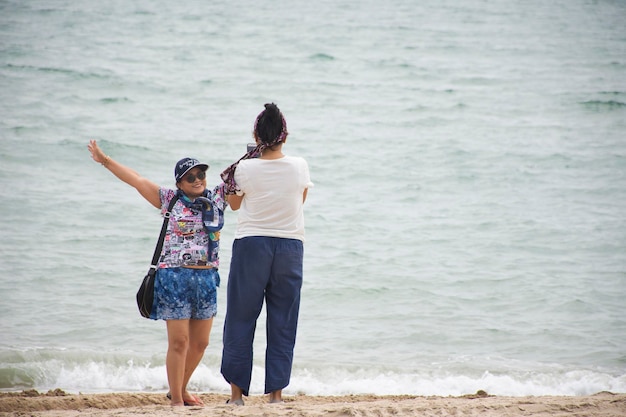 Aziatische Thaise vrouwen moeder en dochter reizen poseren en spelen en selfie per mobiele telefoon op het Ban Krut-strand van Bang Saphan in Prachuap Khiri Khan, Thailand