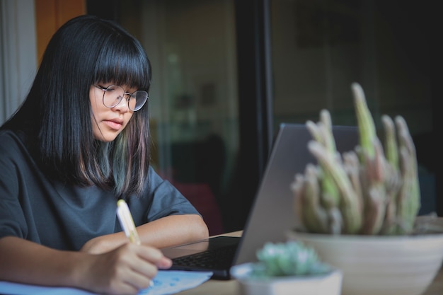 Aziatische tiener die thuis online studeert