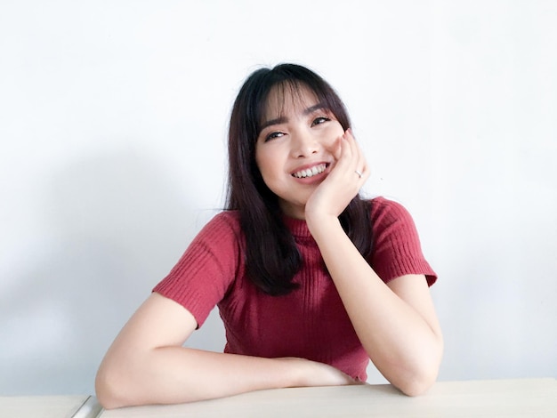 Aziatische tienervrouw die gelukkig glimlacht en naar de camera kijkt
