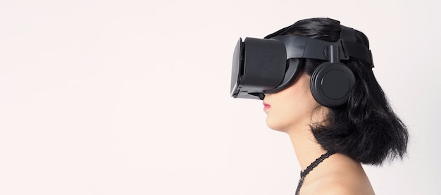 Aziatische tienervrouw die VR- of Virtual Reality-koptelefoon draagt om de digitale simulatiewereld binnen te gaan voor leren en reizen of gamen en meer.