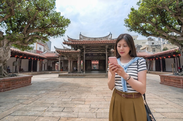aziatische toerist op zoek naar iets via de telefoon. de volgende bestemming vinden