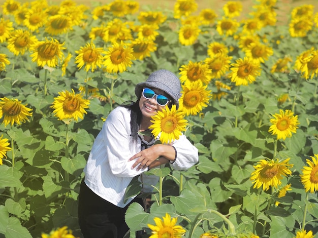 Aziatische toeristenvrouw die zich in geel zonnebloemenlandbouwbedrijf bevinden