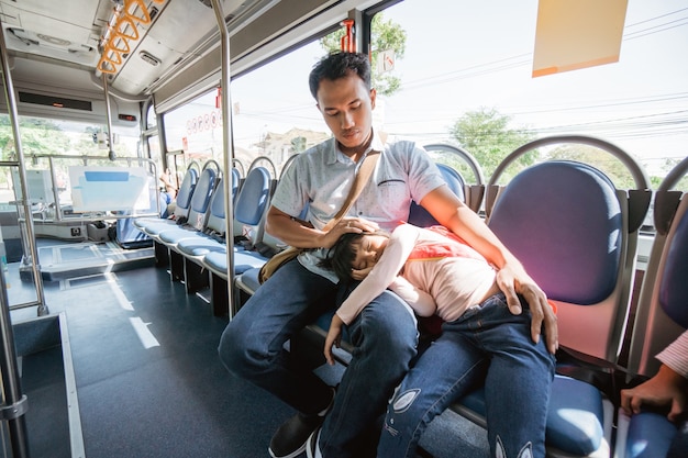 Aziatische vader brengt zijn dochter naar school met het openbaar vervoer per bus