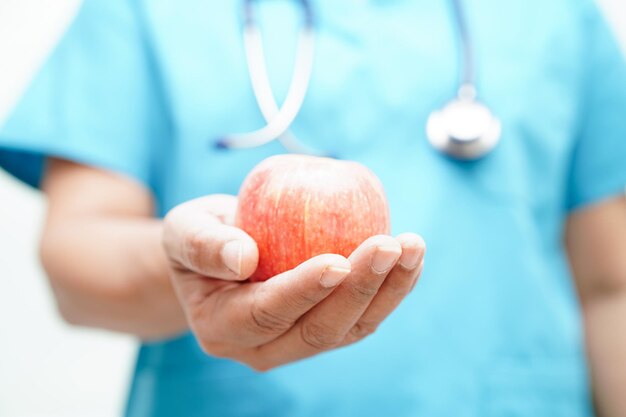 Aziatische voedingsdeskundige die appel gezond voedsel houdt voor patiënt in ziekenhuisvoeding en vitamine