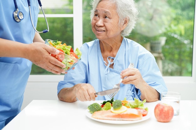 Aziatische voedingsdeskundige met gezond voedsel voor patiënt in ziekenhuisvoeding en vitamine