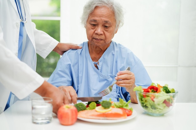 Aziatische voedingsdeskundige met gezond voedsel voor patiënt in ziekenhuisvoeding en vitamine