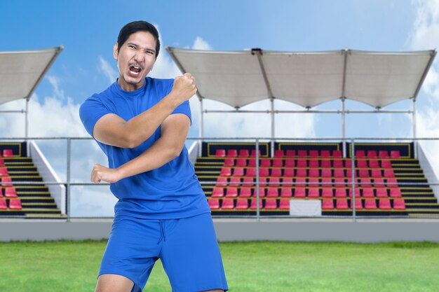 Aziatische voetballer man viert de overwinning in het stadion