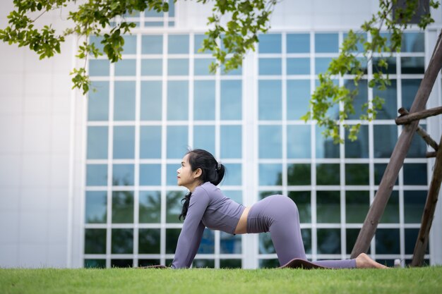 Aziatische vrouw beoefenen van yoga in een stadstuin