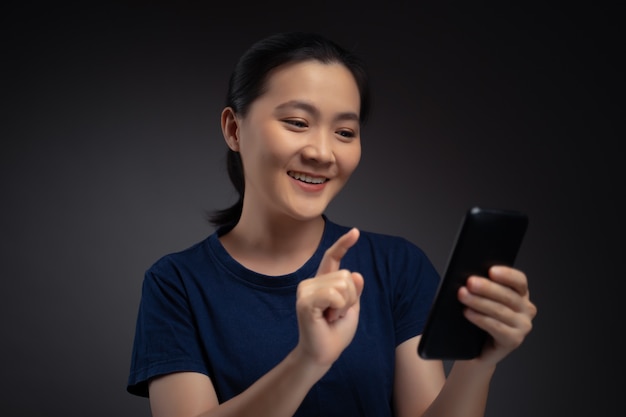 Aziatische vrouw blij verrast bedrijf smartphone geïsoleerd op de achtergrond.