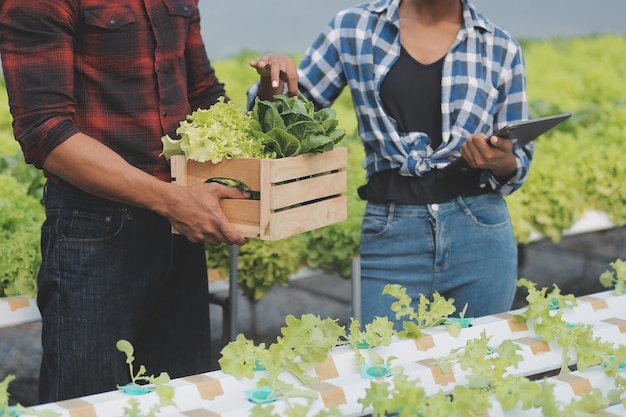 Aziatische vrouw boer met behulp van digitale tablet in moestuin bij kas Business landbouwtechnologie concept kwaliteit slimme boer