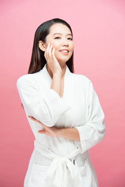 Aziatische vrouw brengt huidverzorging op het gezicht aan