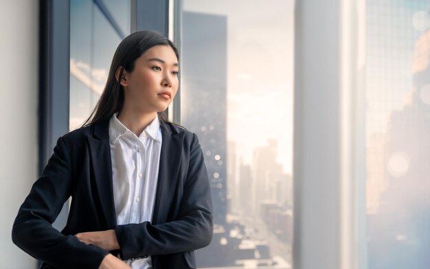 Aziatische vrouw dichtbij venster