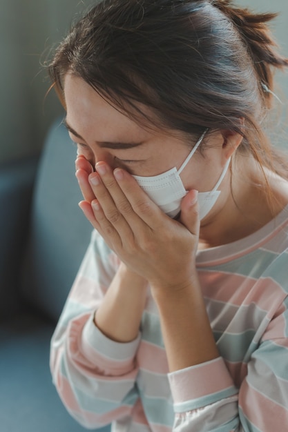 Aziatische vrouw die beschermend hygiënemasker draagt