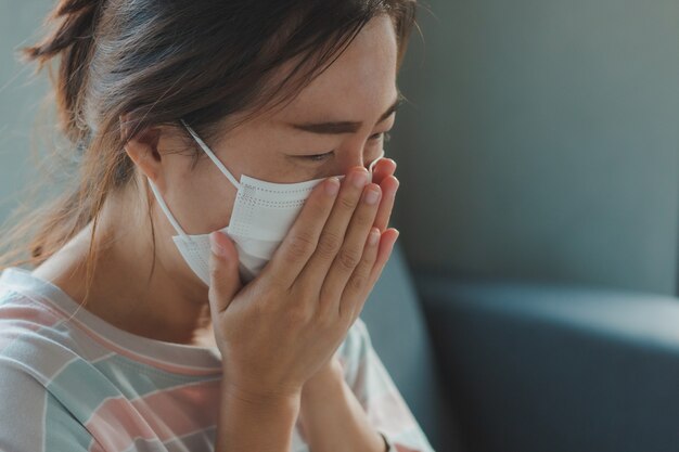 Aziatische vrouw die beschermend hygiënemasker draagt