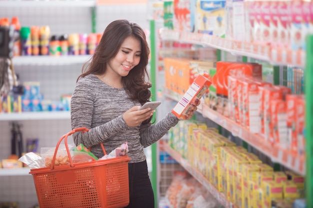 Aziatische vrouw die bij supermarkt winkelt