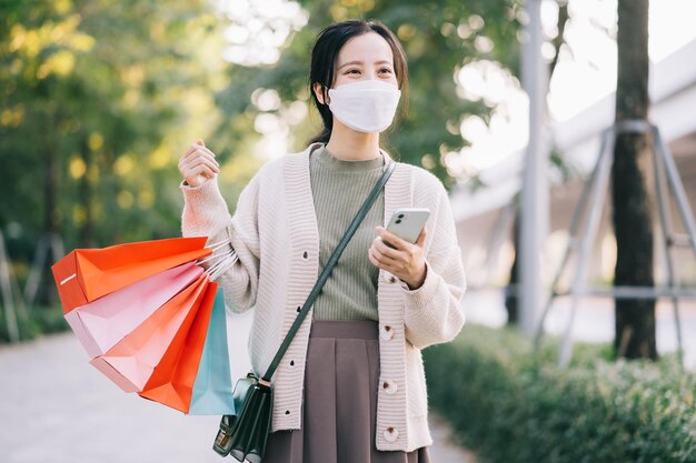 Aziatische vrouw die een masker draagt terwijl ze op straat loopt