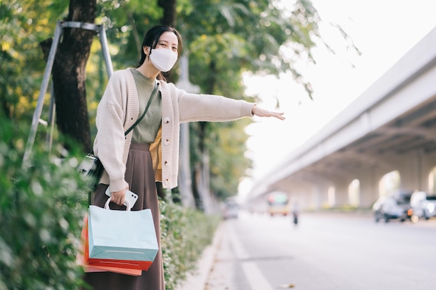 Aziatische vrouw die een masker draagt terwijl ze op straat loopt