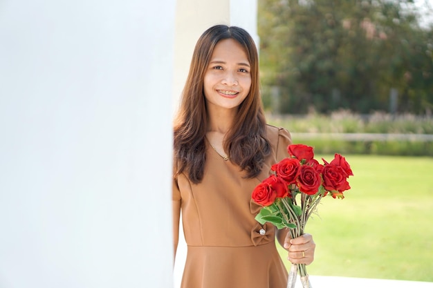 Aziatische vrouw die gelukkig lacht tussen prachtige bloemen