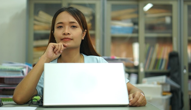 Aziatische vrouw die het computerwerkplan analyseert