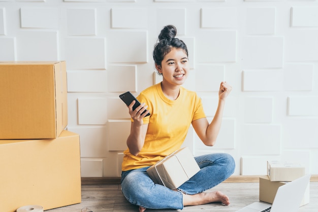 Aziatische vrouw die in de leveringsdienst werken met laptop