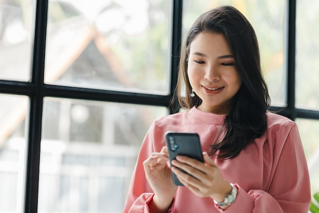 Aziatische vrouw die in een startend bedrijf werkt, gebruikt de telefoon van een jonge getalenteerde vrouw het managementconcept runt het bedrijf van vrouwelijke leiders om het bedrijf te laten groeien