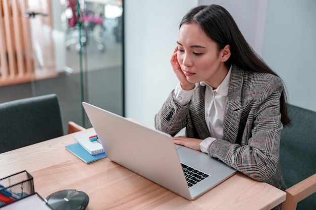 Aziatische vrouw die in het bureau werkt