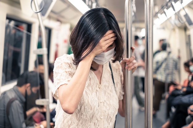 Aziatische vrouw die masker draagt voor het voorkomen van schemering pm 2.5 slechte luchtvervuiling en coronavirus of covid-19