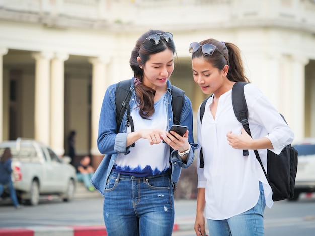 Aziatische vrouw die met mobiele telefoon reist