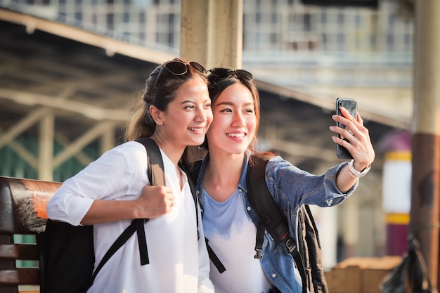 Aziatische vrouw die met mobiele telefoon reist