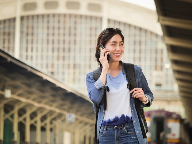 Aziatische vrouw die met mobiele telefoon reist