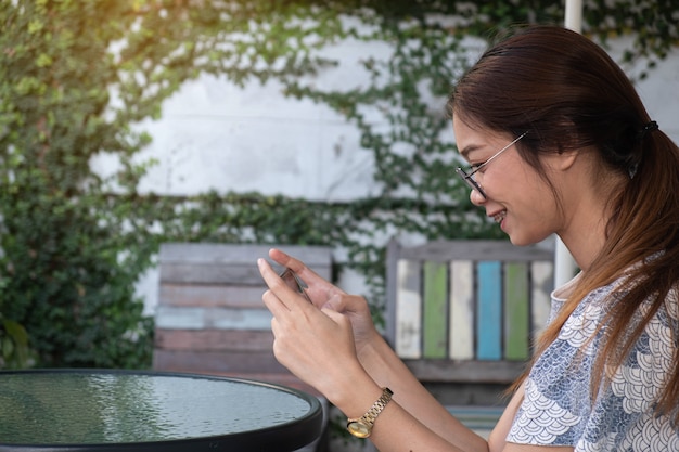 Foto aziatische vrouw die mobiele telefoon met behulp van